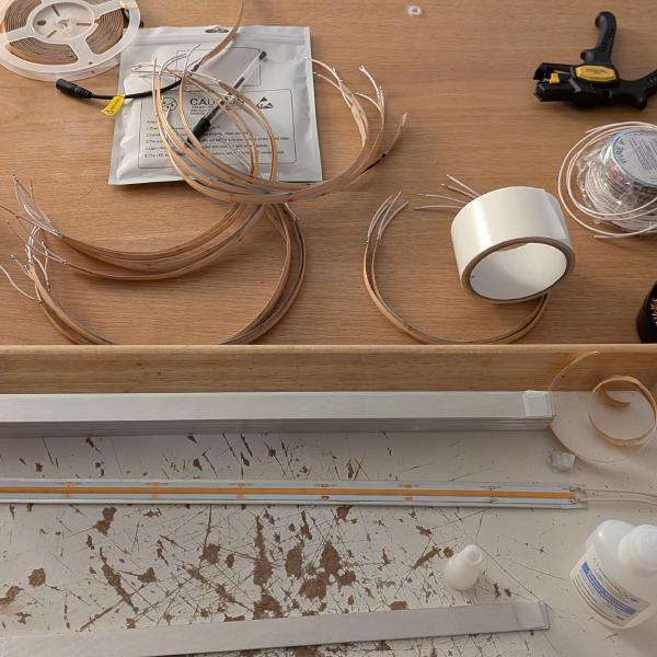 LED strips are cut, wires soldered, and glued on the aluminium supports